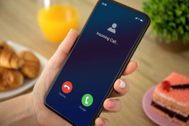 Kadın elleri ekranda gelen arama ile birlikte telefonu tutuyor.