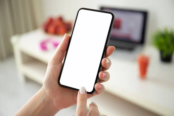 Женские руки держат телефон с изолированным экраном в комнате — стоковое фото