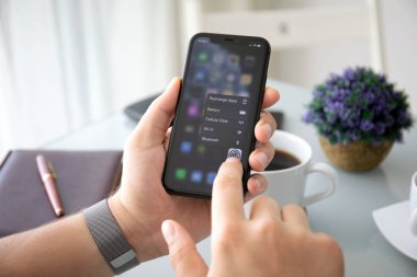 Ev ekranı 13 olan iPhone 11 'i tutan adam.