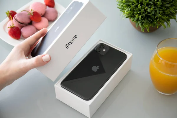 Kadın el ele tutuşma kutusu Apple iPhone 11 masanın altında — Stok fotoğraf