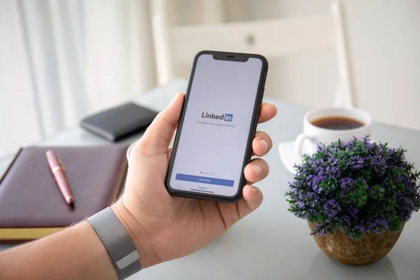 Man hand holding iPhone 11 with app LinkedIn in screen — 스톡 사진