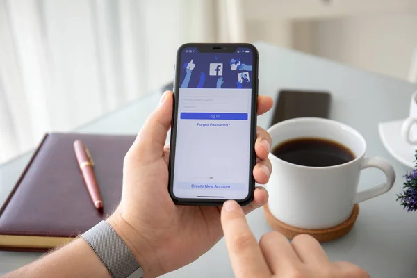 Mann hält iPhone 11 mit Social-Networking-Dienst facebo — Stockfoto