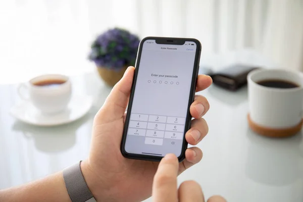 Mann hält iPhone 11 mit PIN-Code auf dem Bildschirm — Stockfoto
