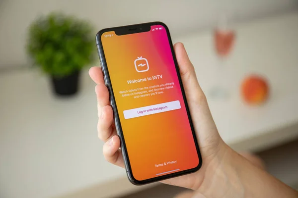 Женщина держит iPhone X социальной сети сервис IGTV Insta — стоковое фото