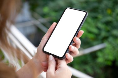 Kadın elleri arka planda izole ekran ile telefonu tutuyor.