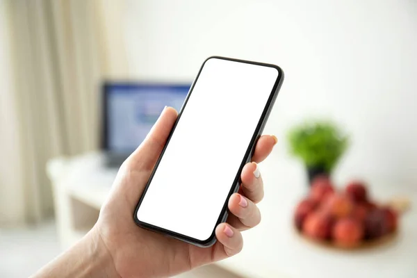 Vrouwelijke hand holding telefoon met geïsoleerde scherm achtergrond van roo — Stockfoto