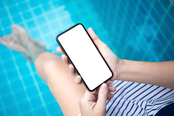 Manos femeninas sosteniendo el teléfono con pantalla aislada en la piscina —  Fotos de Stock