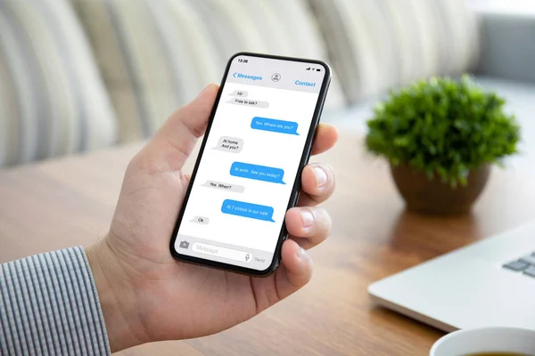 Telefono a mano maschile con app messenger sullo schermo — Foto Stock