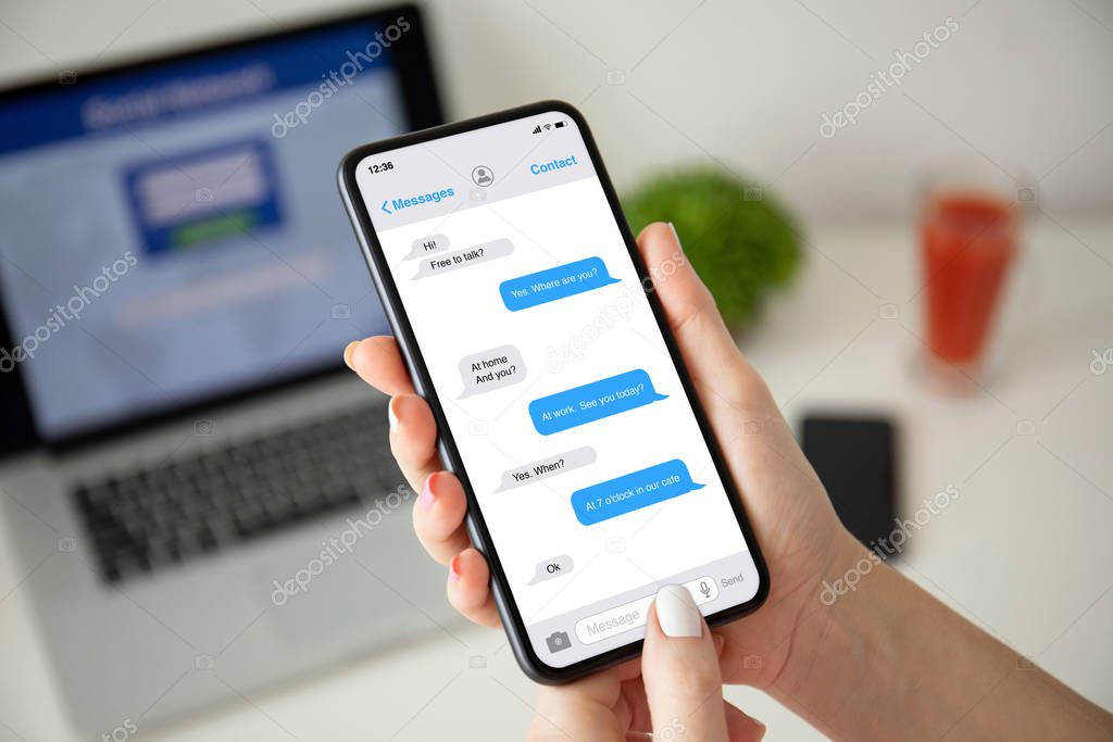 female hands holding phone with app messenger on the screen 