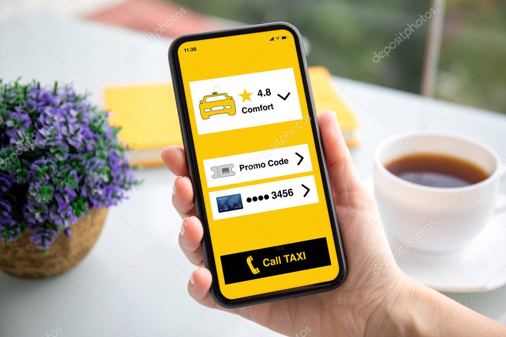 female hand holding phone with app call taxi on screen 