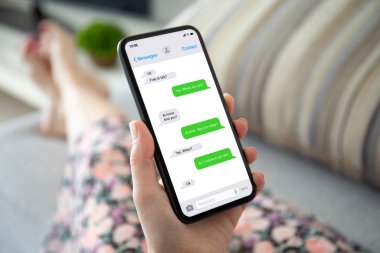 Uygulamalı kuryeyle telefonda konuşan kadın elleri. 