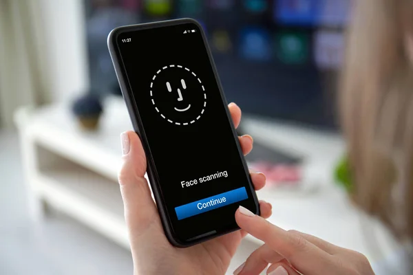 Manos femeninas sosteniendo el teléfono con el escaneo de identificación facial en pantalla — Foto de Stock