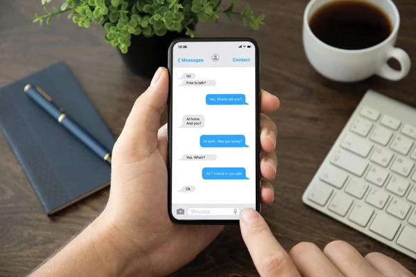 Telefono a mano maschile con app messenger sullo schermo — Foto Stock