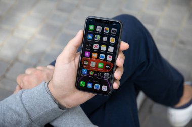 Anapa, Rusya - 26 Eylül 2019: Ekranda IOS 13 ile iPhone 11 'i tutan adam. iPhone Apple tarafından oluşturuldu ve geliştirildi..