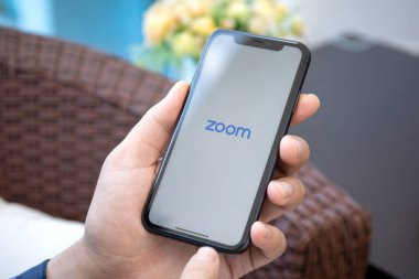 Alanya, Türkiye - 1 Mayıs 2020: Zoom Video İletişim uygulamasını arayan bir adam iPhone 11 'i açtı. iPhone 11 Apple tarafından oluşturuldu ve geliştirildi..