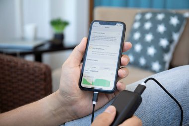 Alanya, Türkiye - 9 Mayıs 2020: Powerbank RavPower ve iPhone 11 'i ekranda uygulama pili ile elinde tutan adam.
