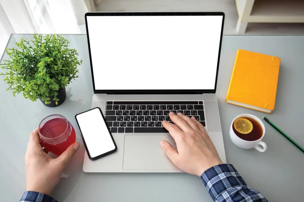 ノートパソコンの男性の手とオフィスのテーブルの上に隔離された画面を持つ電話のキーボード — ストック写真