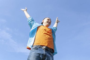 Adam kollarını gökyüzüne uzatmış duruyor.