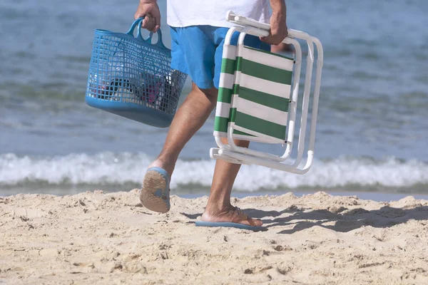 Un uomo anziano cammina lungo la spiaggia — Foto Stock