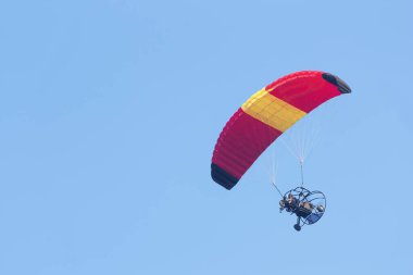 Gökyüzü arka planında motoru olan bir paraglider