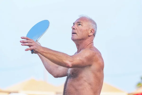Adulto macho jugando matkot en la playa — Foto de Stock