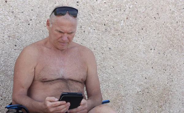 Hombre leyendo un libro electrónico en la playa —  Fotos de Stock