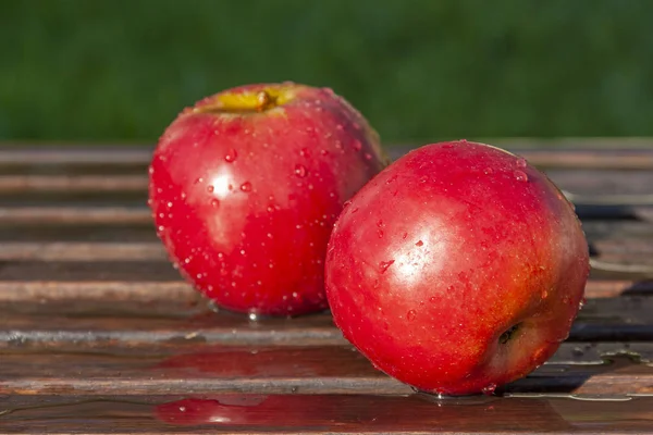 红苹果躺在木制长椅上 — 图库照片