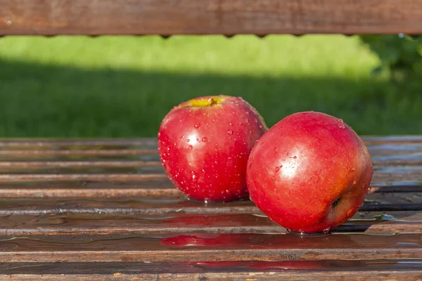 Pommes rouges reposent sur un banc en bois — Photo