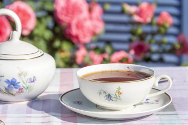 Güllerin arka planında İngiliz usulü çay