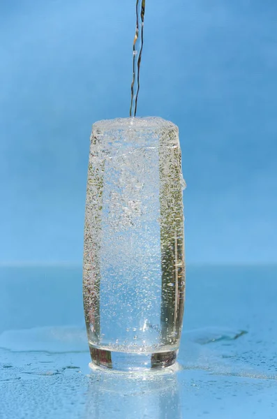 Ein Strahl Mineralwasser, der in ein Glas fließt — Stockfoto