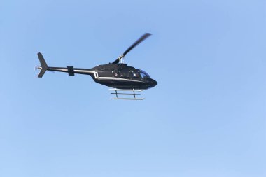 Mavi arka planda siyah yolcu helikopteri