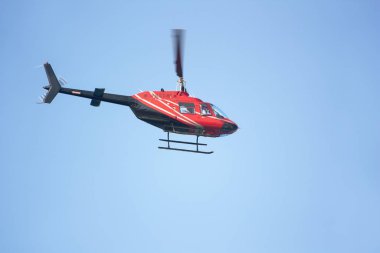 Mavi arka planda kırmızı yolcu helikopteri