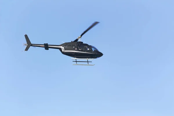 Mavi arka planda siyah yolcu helikopteri — Stok fotoğraf