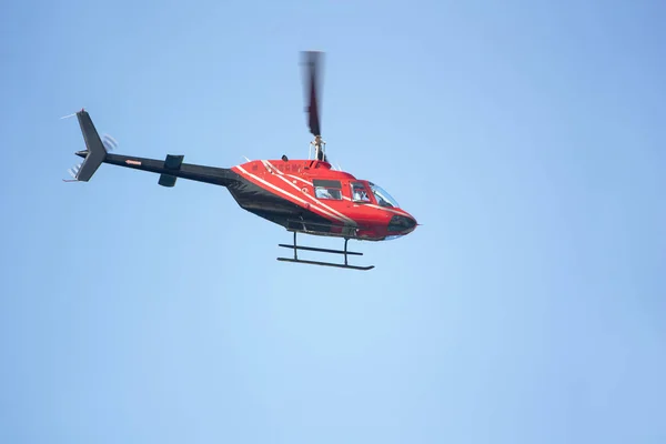 Κόκκινο ελικόπτερο επιβατών σε μπλε φόντο ουρανό — Φωτογραφία Αρχείου