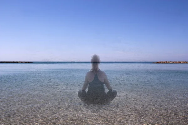Silhouette di una ragazza meditante contro il mare — Foto Stock