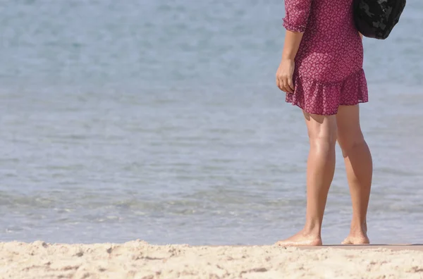 Молода жінка стоїть біля води на пляжі — стокове фото
