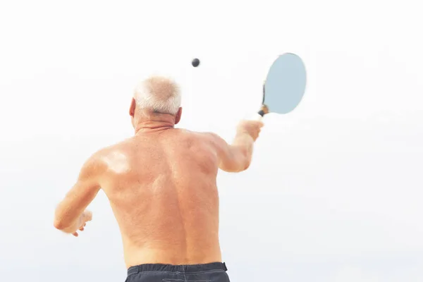 Adulto macho jugando matkot en la playa — Foto de Stock