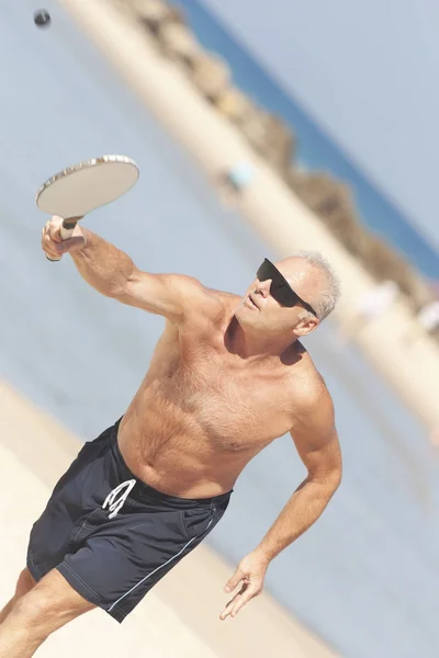 Erwachsener Mann spielt Matkot am Strand — Stockfoto