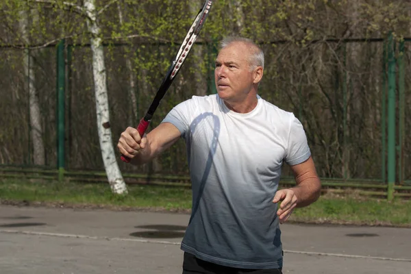 Чоловік грає в теніс на відкритому корті — стокове фото