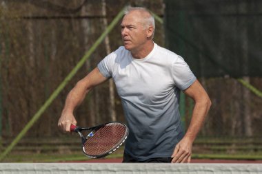 Sahada tenis oynayan adam.