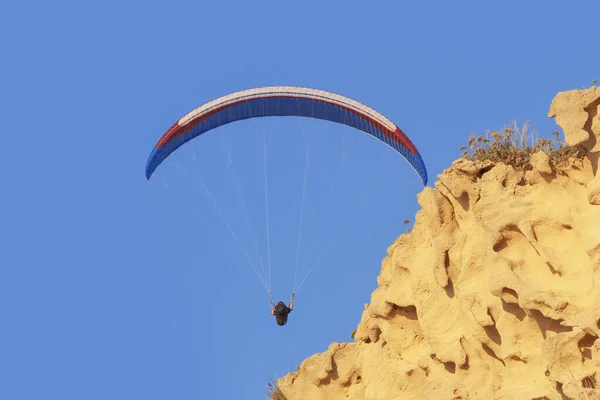 Paraglider blauwe lucht en gele zandsteen klif — Stockfoto
