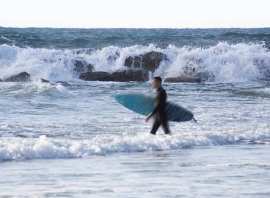 Fırtınalı deniz, ön planda çözünmüş bir sörfçü var.