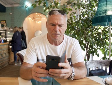 Kafede oturan yaşlı bir adam.