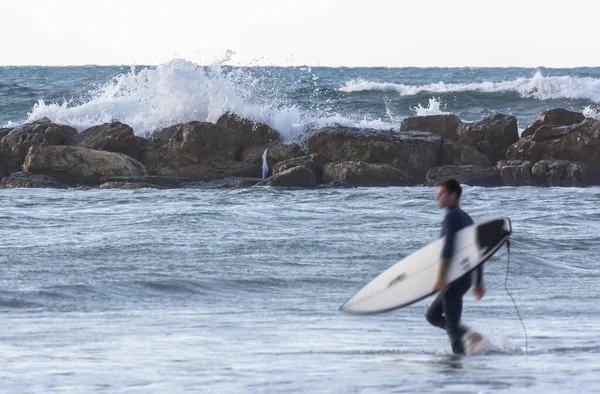 Mar tormentoso con un surfista desenfocado en primer plano — Foto de Stock