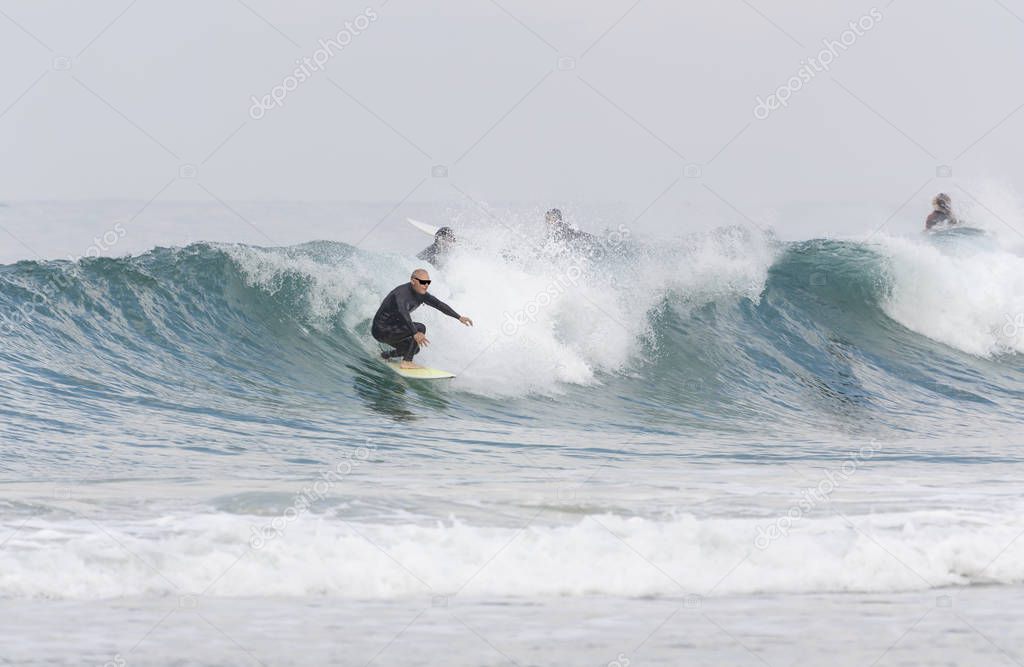 A man over 60 years old riding a surfboard