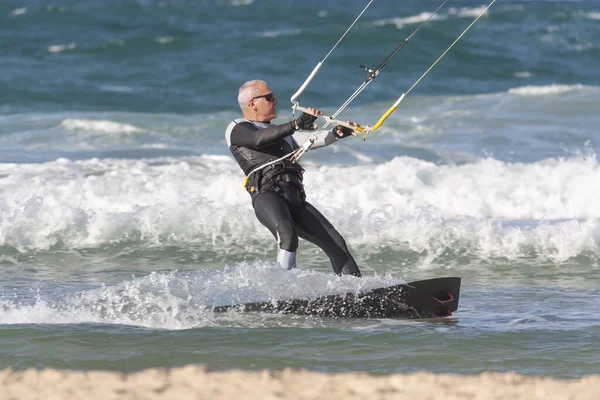 Un hombre mayor de 60 años monta un kitesurf — Foto de Stock