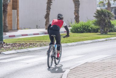 Yolda bisiklet süren tanımlanamayan bir bisikletçi.