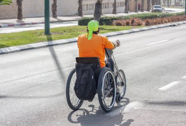 Engelli bir sporcu özel bir üç tekerlekli bisiklete biner.