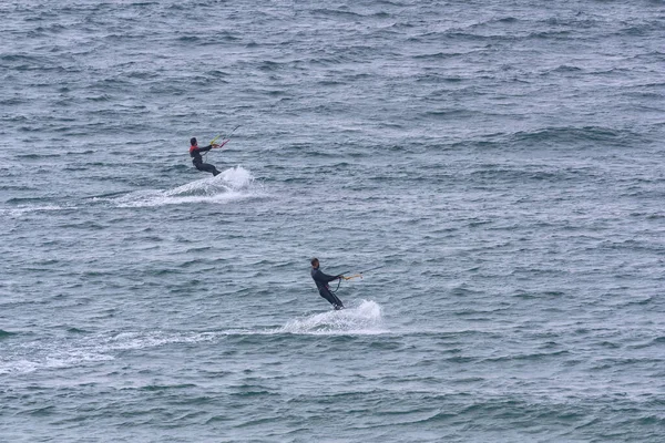 Dos kitesurfistas se deslizan en paralelo sobre el agua — Foto de Stock