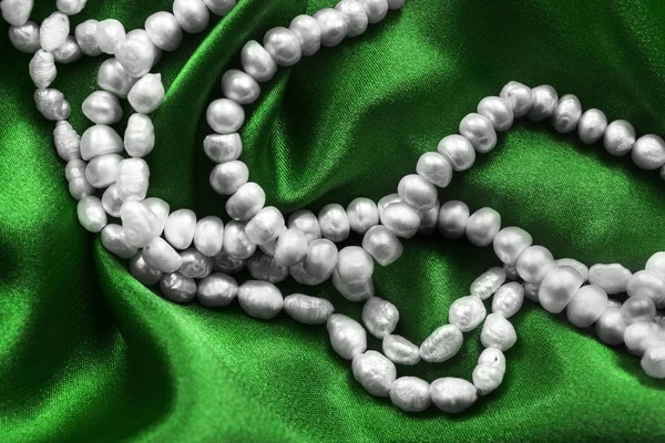 珍珠镶嵌在绿色的丝缎 — 图库照片